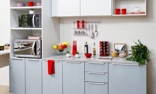 Imagem com foco nos armários de cozinha da linha Agata, na cor preta. Em cima dos móveis, há utensílios de decoração.