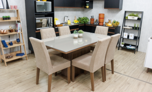 A imagem ilustra uma mesa de jantar de madeira retangular com seis cadeiras estofadas.