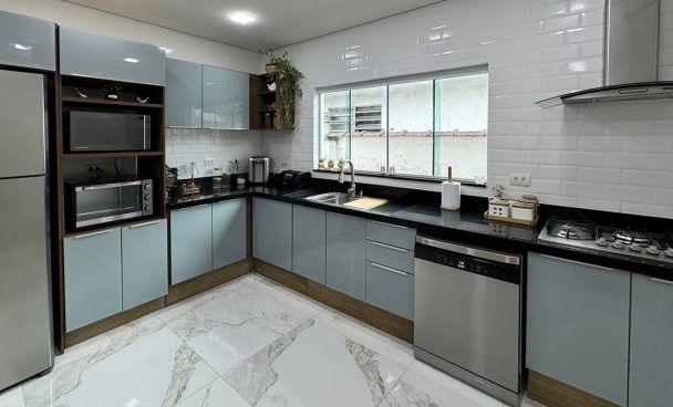 Armário de cozinha planejado de madeira, utensílios organizados e decoração na cor amarela.