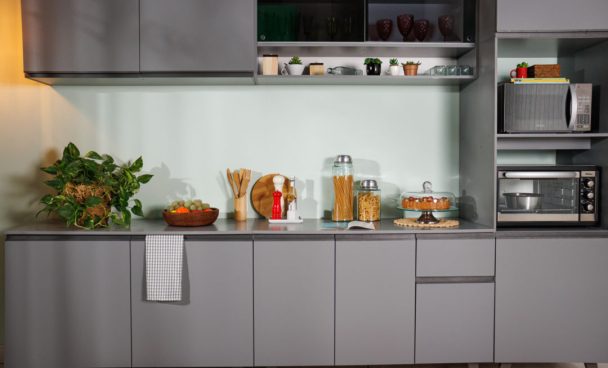 Cozinha Nice Madesa, na cor cinza, decorada com diversos utensílios e eletrodomésticos nos nichos à direita.