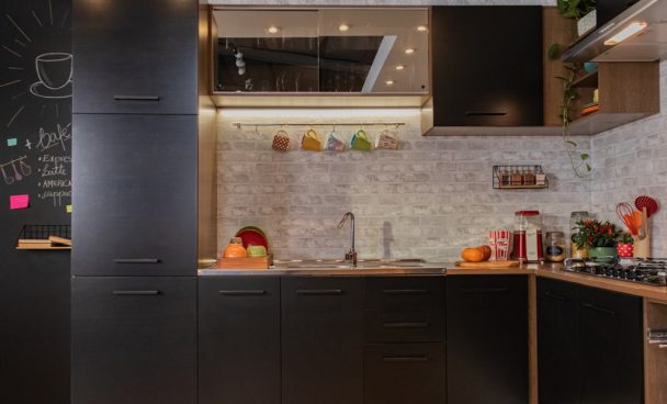 Cozinha Madesa Agata na cor preta, com eletrodomésticos e decorada.