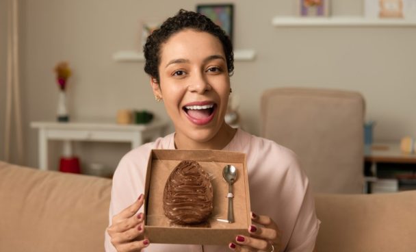 Happy,Woman,Showing,Stuffed,Chocolate,Easter,Egg,At,Home.