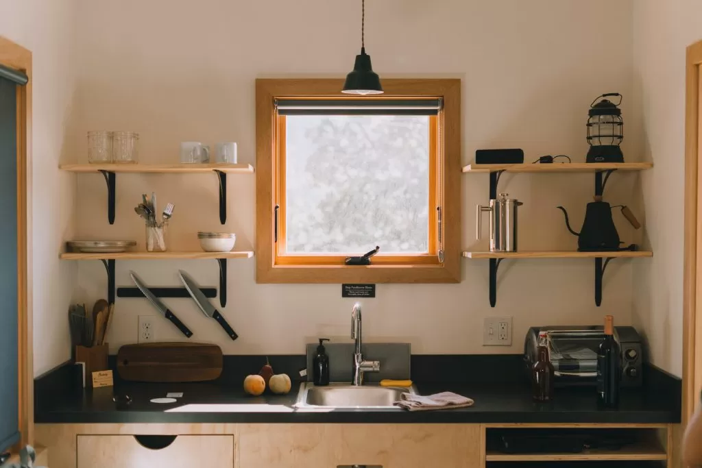 Cozinha pequena com prateleiras na parede para otimização de espaço.