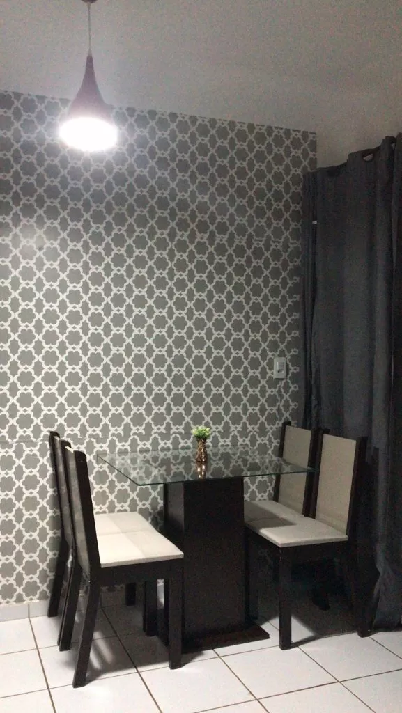 Sala de jantar Madesa, contando com uma mesa e quatro cadeiras, e decorada com papel de parede.