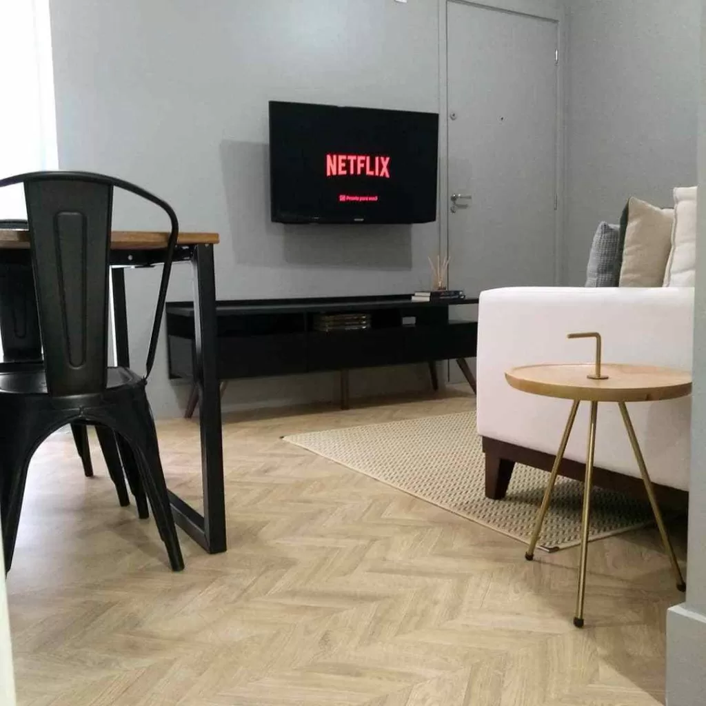 Sala de cliente pintada na cor cinza com um Rack Madesa preto e sofá branco.