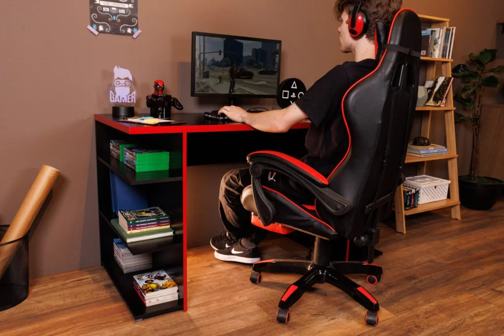 A imagem ilustra um jovem jogando em seu computador gamer mostrando ideias para trabalhar em casa no que diz respeito ao conforto da sua cadeira gamer.