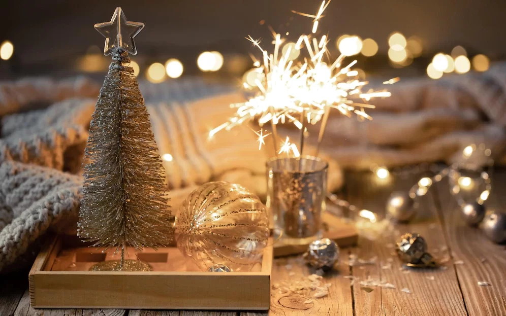 A imagem ilustra itens decorativos para uma ceia de ano novo simples e barata, incluindo velas, bolas e presentes.