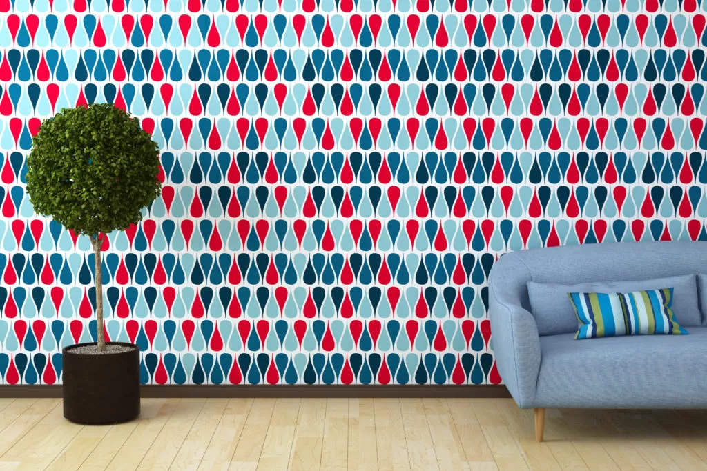 a imagem ilustra a pintura geométrica em uma sala com um sofá azul e um vaso de plantas.