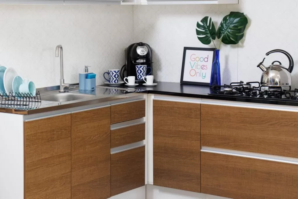Foto fechada do balcão da cozinha Acordes, decorado, nas cores branco e amadeirado.