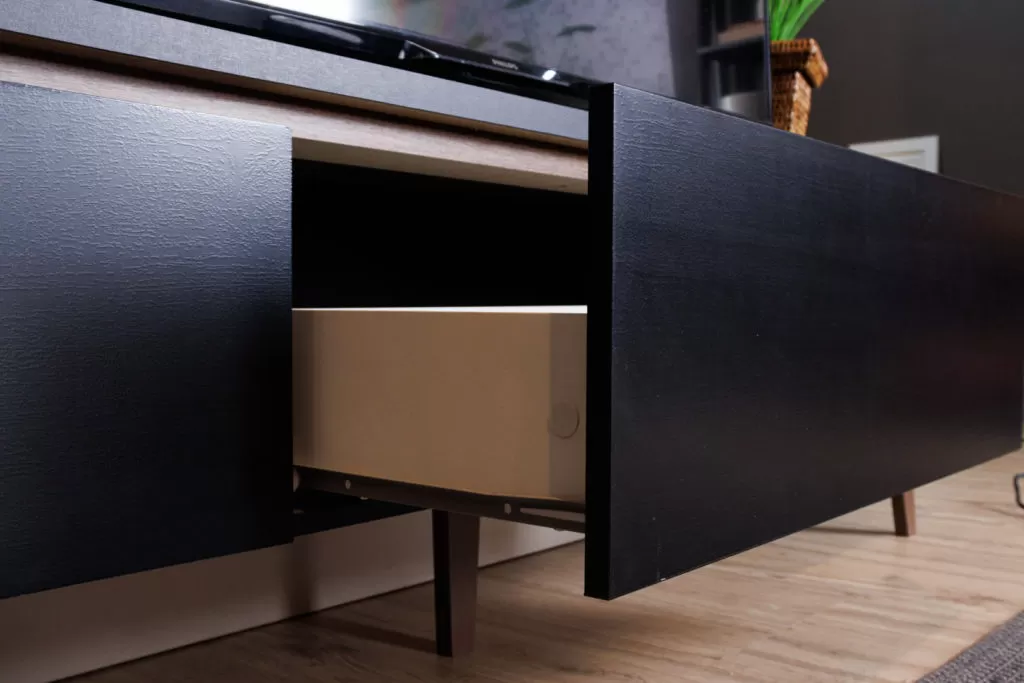 Rack Reims Madesa, na cor preta, com a gaveta aberta e foco no acabamento.