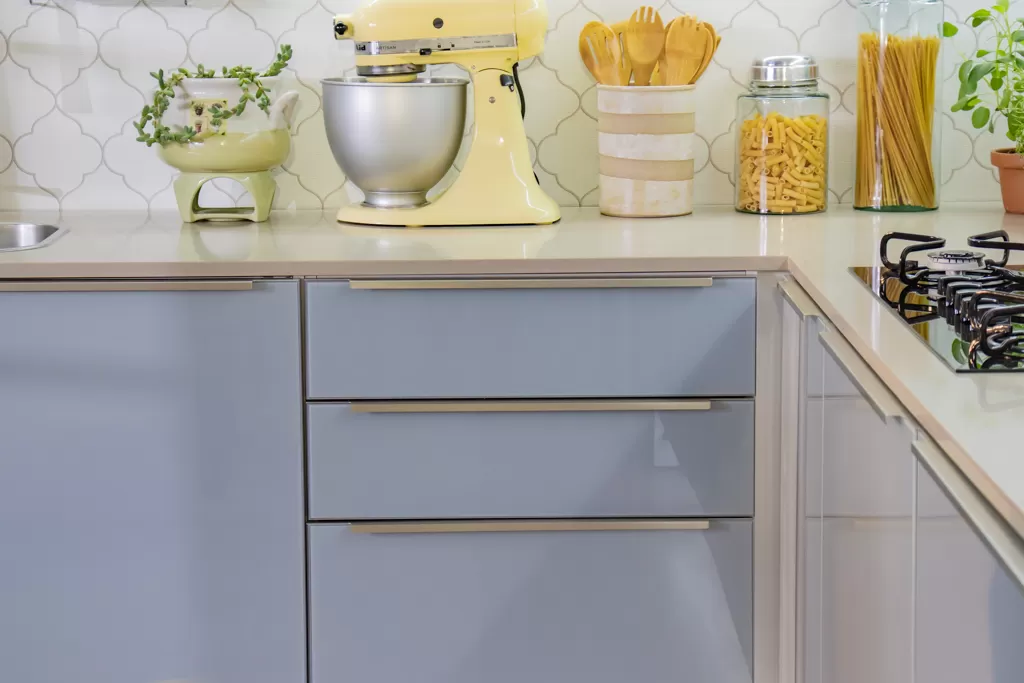 Balcão da cozinha Lux Madesa, com gavetas e decorado com utensílios, potes e plantas.