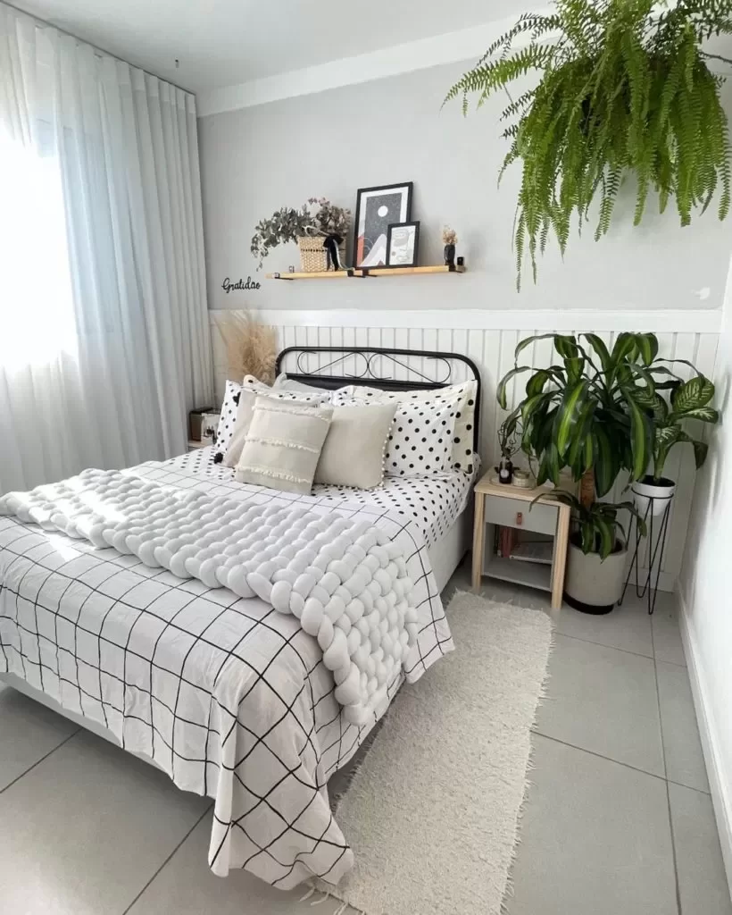 Quarto de solteiro com decoração minimalista, utilizando plantas e prateleiras.