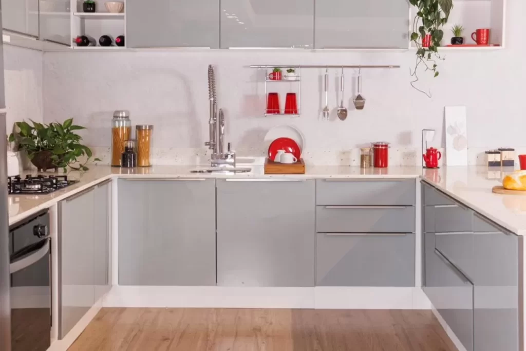 Cozinha em U Lux Madesa, nas cores branco e cinza, decorada com utensílios e eletrodomésticos.