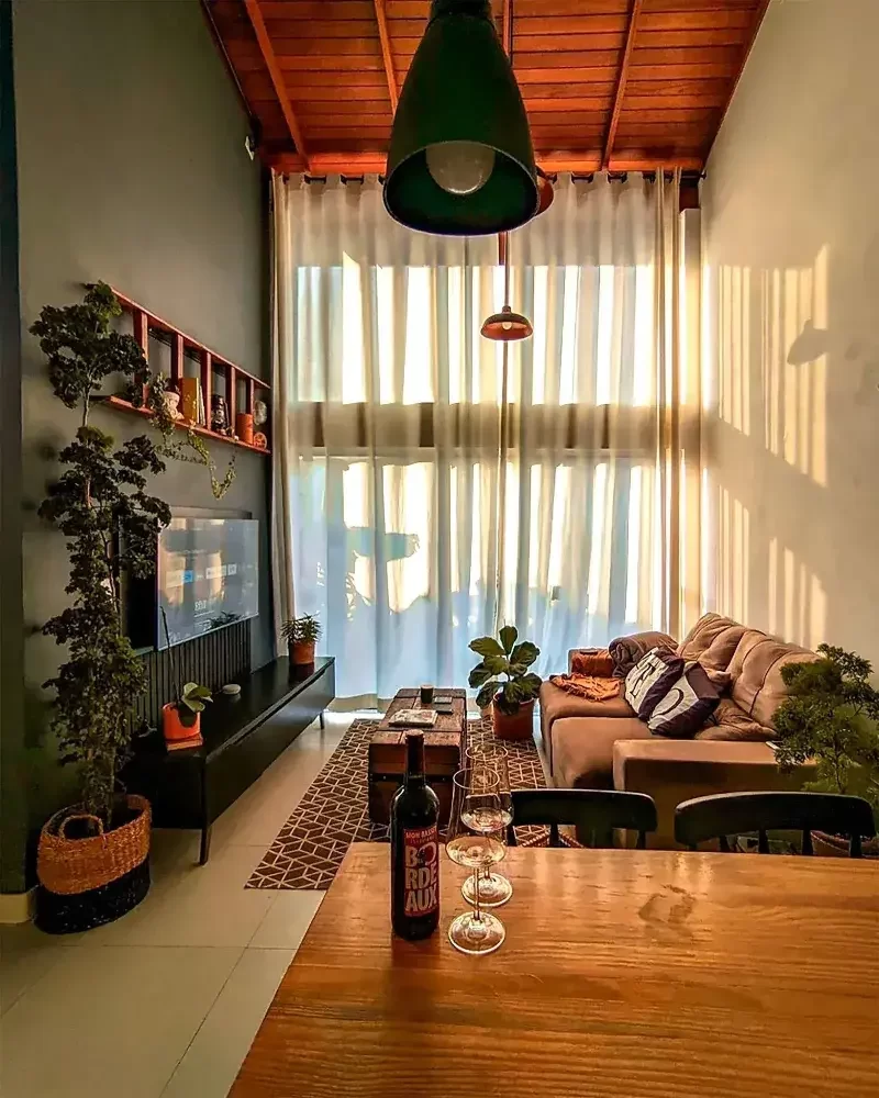 Sala de estar com rack para TV Madesa, com sofá à direita e mesa de madeira como divisória à frente.