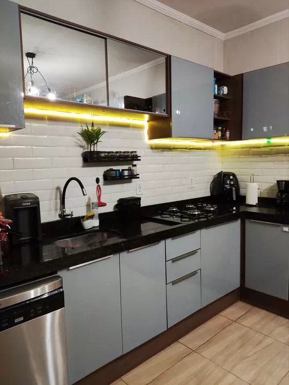 uma cozinha cinza com iluminaçõ em led amarelo está em foco