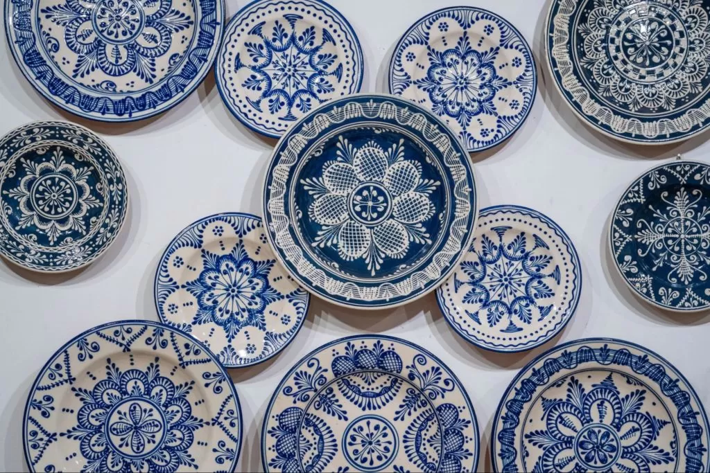 pratos brancos com padrões em mandalas azuis estão dispostos sobre fundo branco