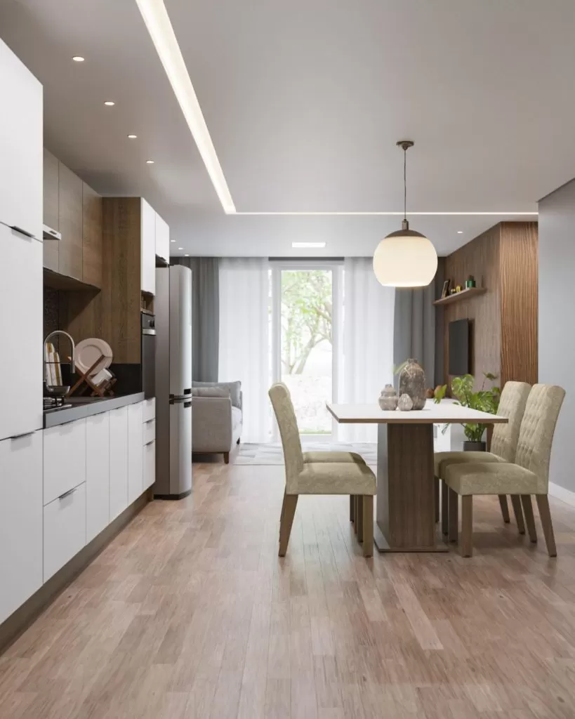 cozinha moderna com armários brancos, eletrodomésticos em inox e bancada de granito. A iluminação é suave, com um design contemporâneo. Um bar com bancos altos complementa o espaço.