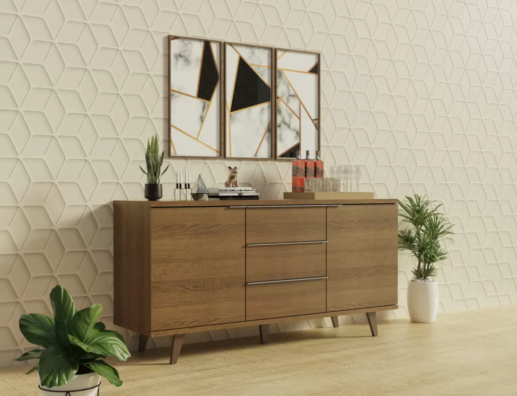móvel de madeira escura com prateleira superior, decorado com um vaso de planta pequena, velas e um objeto decorativo em forma de diamante. Acima, há dois espelhos com molduras geométricas em tons de dourado e preto. O fundo apresenta uma parede texturizada em padrões hexagonais e há plantas em vasos no chão ao lado do móvel. O piso é de madeira clara.