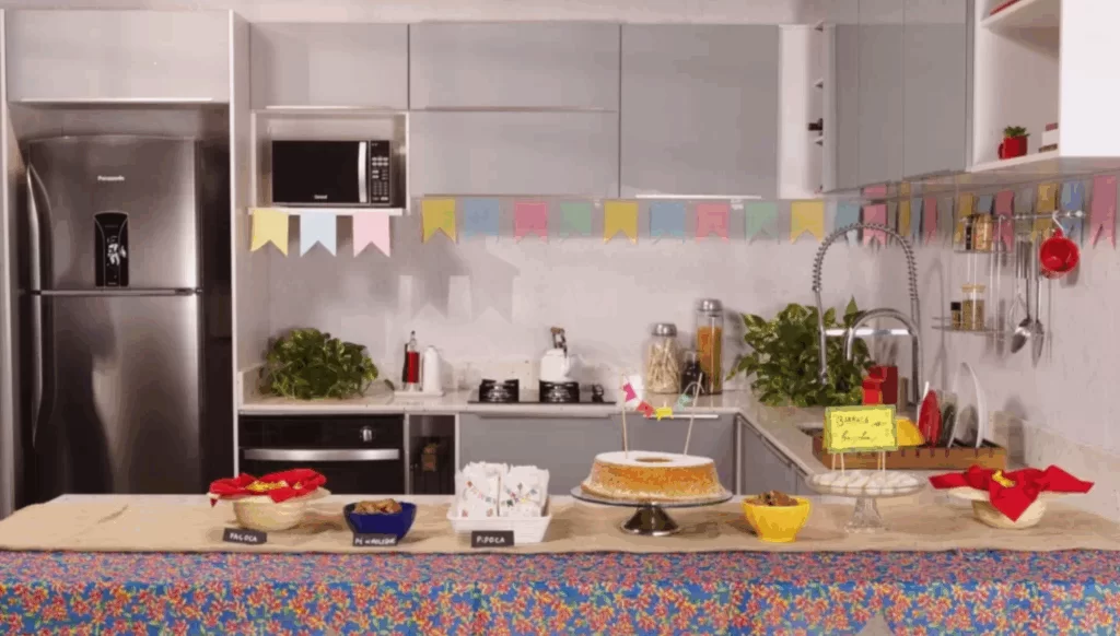 Cozinha decorada com bandeirinhas de festa junina, com comidas típicas na bancada.