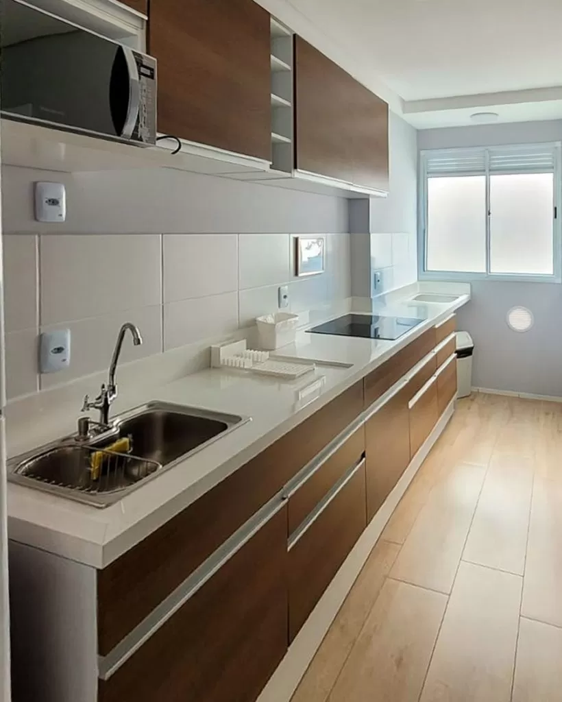 Uma cozinha moderna com uma panela sobre um fogão de indução preto na bancada.