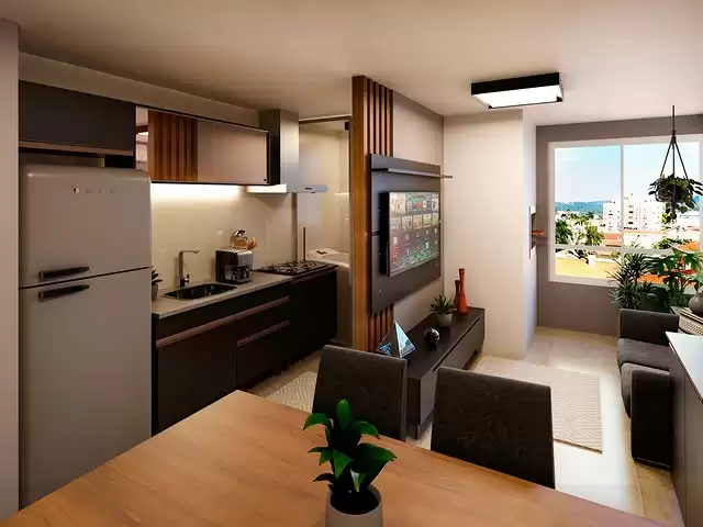 Sala de estar e cozinha integradas, com uma televisão grande na parede, um sofá ao lado da janela com vista para prédios e árvores. Uma mesa de jantar com uma planta no centro, uma geladeira branca ao lado da cozinha, armários escuros na cozinha, uma luminária de teto retangular e uma planta pendurada na varanda.