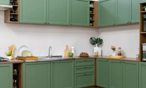 Armário de cozinha da linha Vik. Cozinha com portas verde floresta com caixaria em amadeirado rústico escuro em frente a uma paree clara.
