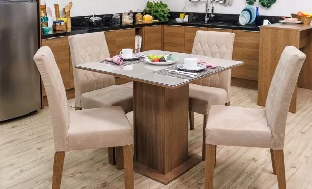 Sala de jantar Madesa, com a mesa posta. Ao fundo, cozinha Madesa decorada com utensílios e eletrodomésticos.