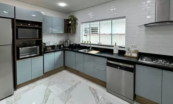 Armário de cozinha planejado de madeira, utensílios organizados e decoração na cor amarela.
