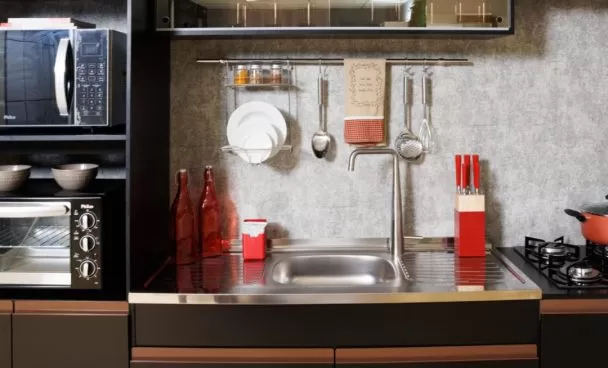 Foto fechada da cozinha completa Reims, na cor preta, decorada com utensílios e eletrodomésticos.